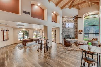 A spacious living room with a fireplace and a dining table set up. at San Montego Apartments, Arizona